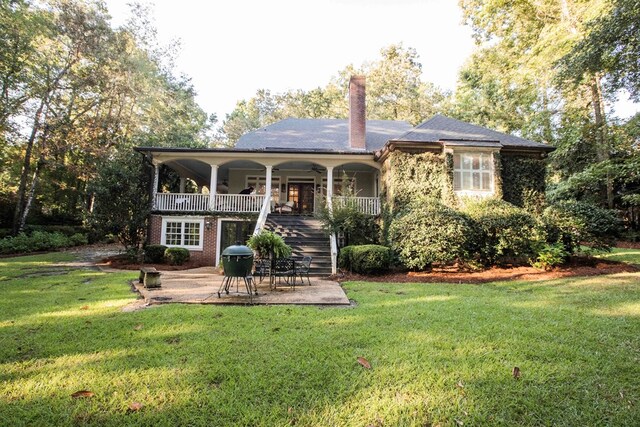 rear view of house featuring a yard and a patio