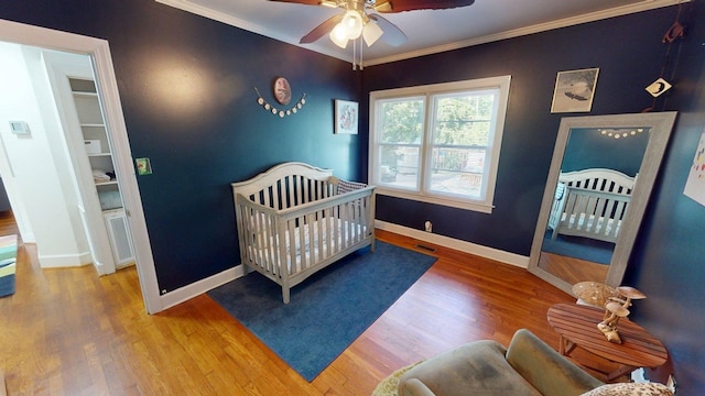 303 Glenwood Dr, Thomasville, GA 31792 - bedroom with ornamental molding, a crib, wood finished floors, and a ceiling fan