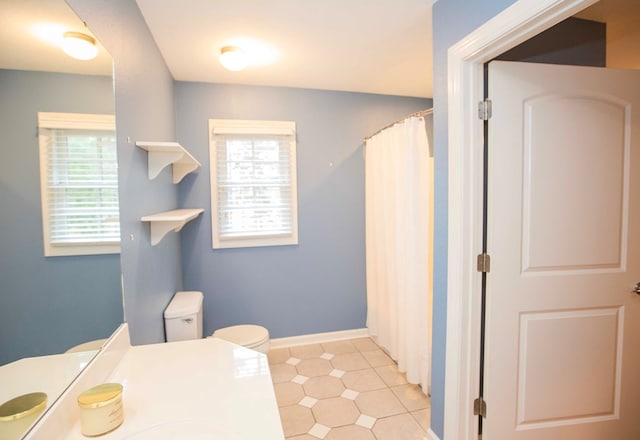 bathroom featuring tile patterned flooring, vanity, plenty of natural light, and toilet