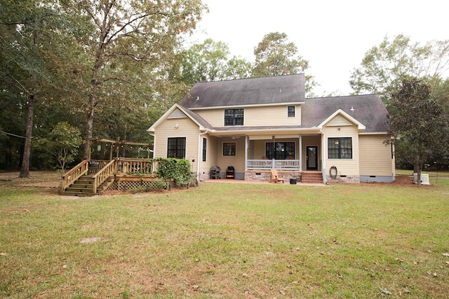 rear view of property featuring a deck and a lawn