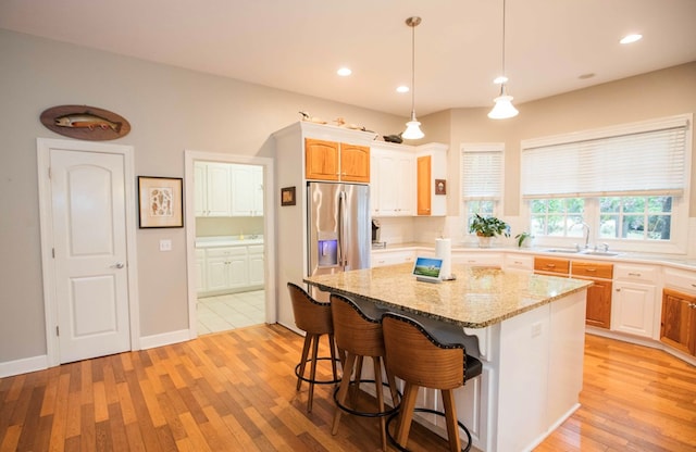 kitchen featuring a center island, sink, light hardwood / wood-style floors, and stainless steel fridge with ice dispenser