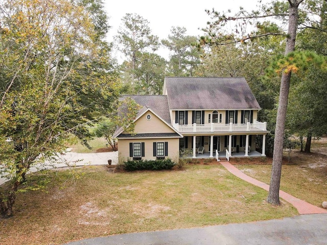 colonial house featuring a patio area and a front lawn