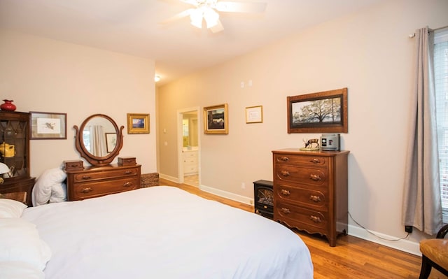 bedroom with ceiling fan, connected bathroom, and light hardwood / wood-style floors