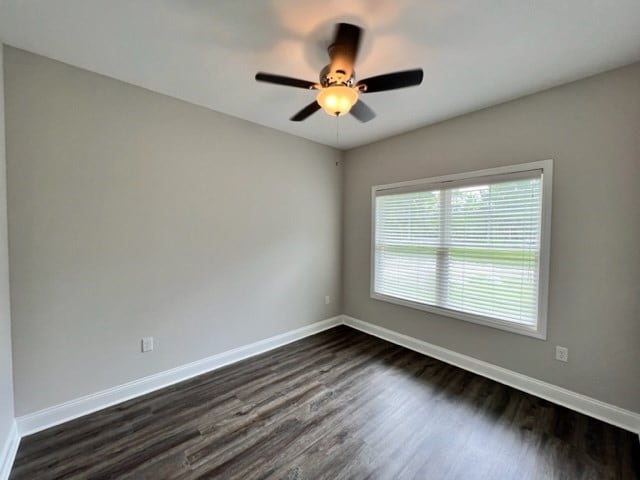 unfurnished room with ceiling fan and dark hardwood / wood-style flooring