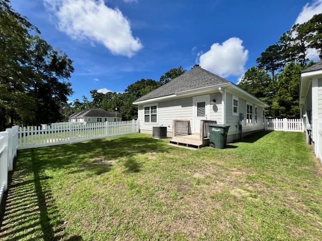 back of property featuring cooling unit and a yard