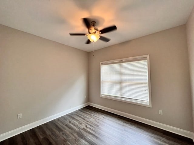 spare room with ceiling fan and dark hardwood / wood-style floors