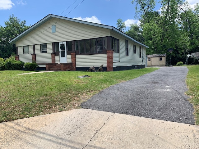 view of front facade featuring a shed and a front lawn