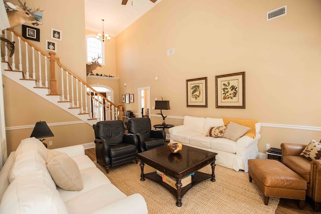 living room featuring crown molding, a notable chandelier, hardwood / wood-style floors, and a high ceiling