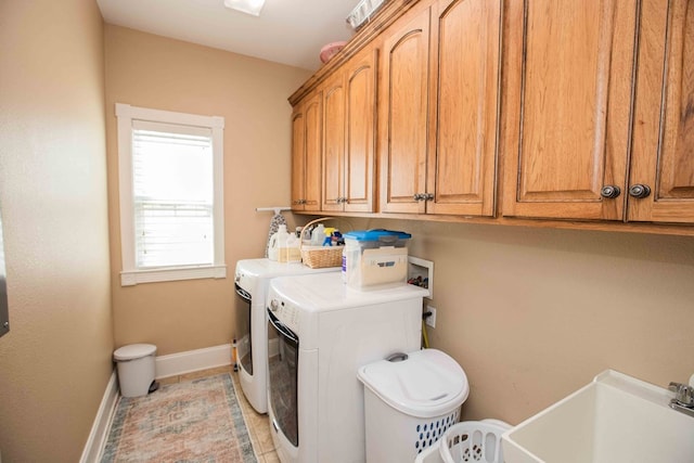 clothes washing area with sink, light tile patterned floors, cabinets, and washing machine and clothes dryer