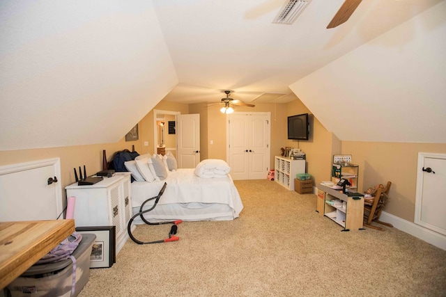 bedroom with vaulted ceiling, light colored carpet, ceiling fan, and a closet