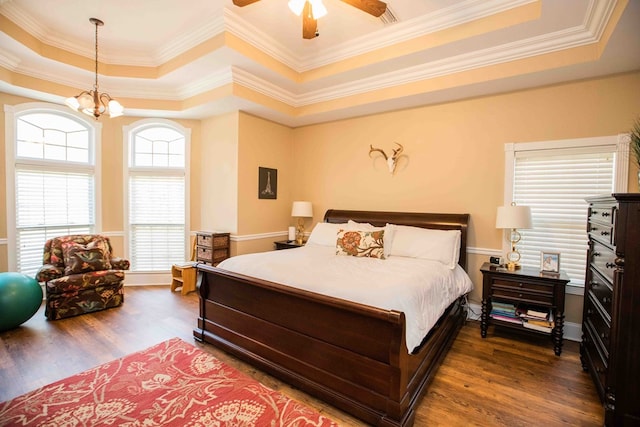 bedroom featuring an inviting chandelier, a tray ceiling, and dark hardwood / wood-style floors