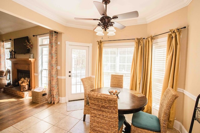 dining area with crown molding, light tile patterned floors, and ceiling fan