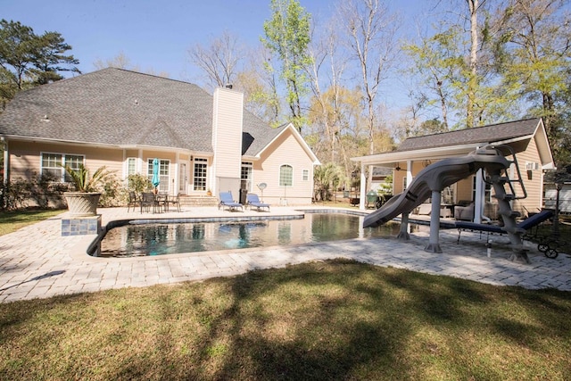 back of house with a patio area and a lawn