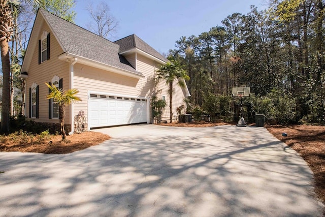 view of front of home with cooling unit and a garage