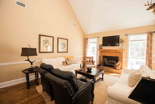 living room with a fireplace, high vaulted ceiling, and dark hardwood / wood-style floors