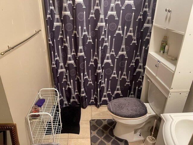 full bath with tile patterned floors, toilet, and curtained shower