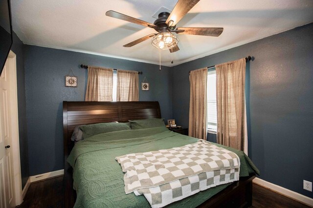 bedroom with ceiling fan and dark hardwood / wood-style flooring