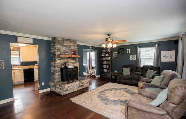 living room featuring dark hardwood / wood-style floors, a wood stove, ceiling fan, crown molding, and a textured ceiling