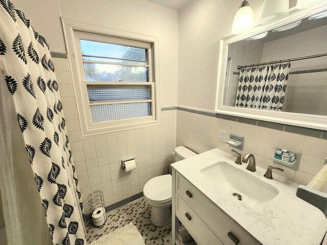 bathroom featuring vanity, curtained shower, tile walls, and toilet