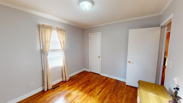 unfurnished bedroom featuring crown molding and light wood-type flooring