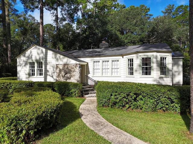 view of front facade with a front lawn and a chimney