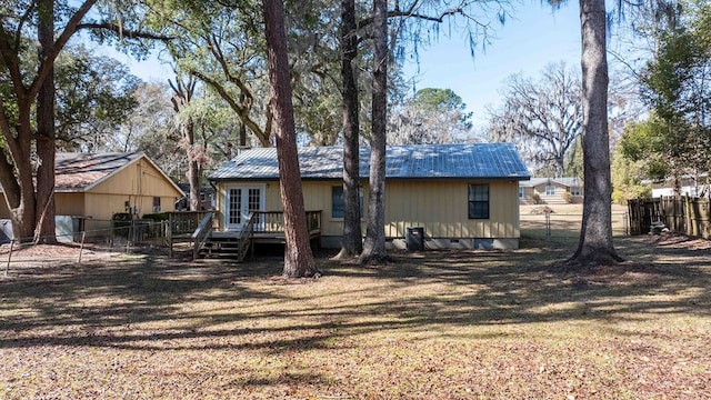 view of front of property with a wooden deck, a front lawn, and central air condition unit