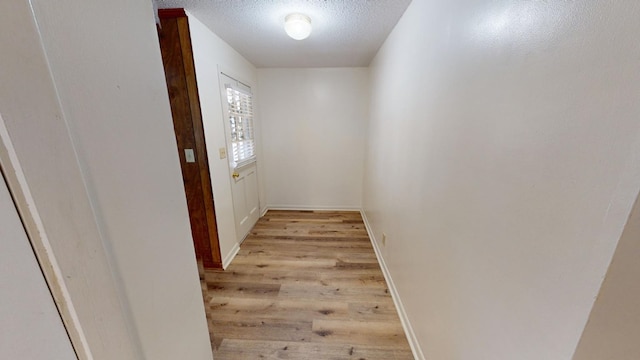 entryway with a textured ceiling and light hardwood / wood-style flooring