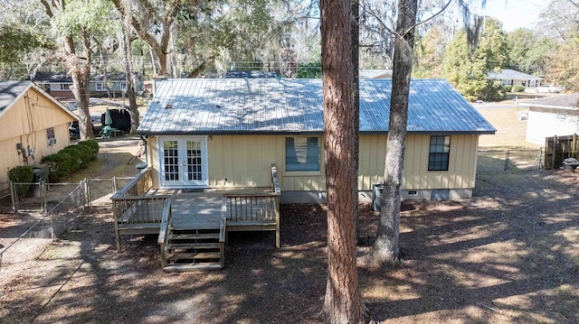 rear view of house with a wooden deck and french doors