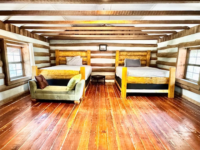bedroom with beam ceiling and wood-type flooring