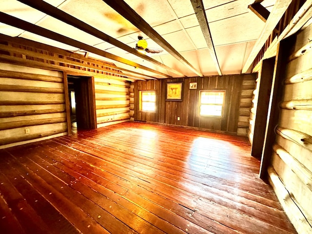 spare room with lofted ceiling with beams and wood-type flooring
