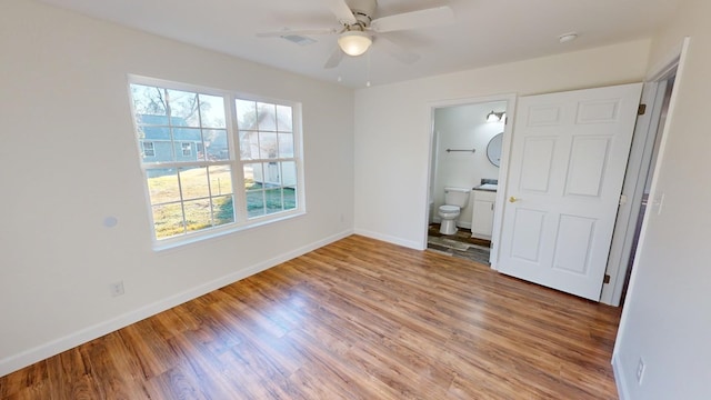 40 Beacon St, Camilla, GA 31730 - unfurnished bedroom with baseboards, wood finished floors, ensuite bath, and a ceiling fan