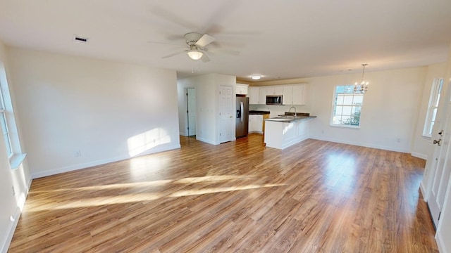 40 Beacon St, Camilla, GA 31730 - unfurnished living room with a chandelier, a sink, light wood-style flooring, a ceiling fan, and baseboards