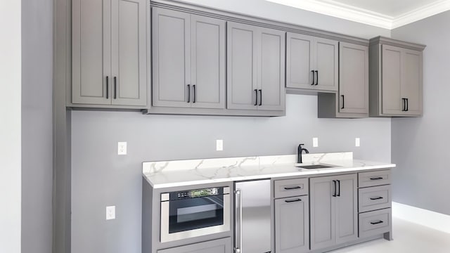 347 Madison Grv, Thomasville, GA 31757 - kitchen with gray cabinetry, a sink, appliances with stainless steel finishes, light stone counters, and ornamental molding