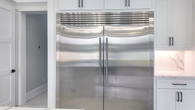 347 Madison Grv, Thomasville, GA 31757 - kitchen with built in refrigerator, white cabinets, and light stone countertops