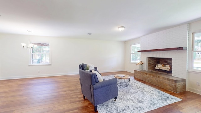 193 E Live Oak Cir, Thomasville, GA 31792 - living room with wood finished floors, a chandelier, and a brick fireplace
