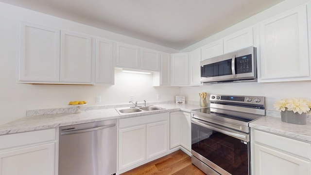 193 E Live Oak Cir, Thomasville, GA 31792 - kitchen featuring appliances with stainless steel finishes, light wood finished floors, white cabinets, and light stone countertops