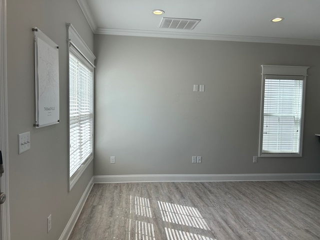 spare room featuring hardwood / wood-style flooring, ornamental molding, and a wealth of natural light