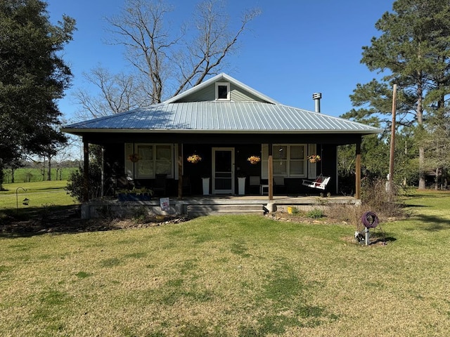 view of front of home featuring metal roof, covered porch, and a front lawn