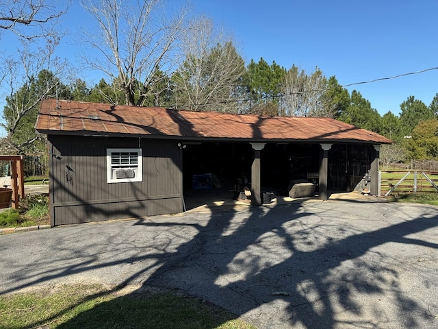 exterior space featuring aphalt driveway, an outdoor structure, and a carport