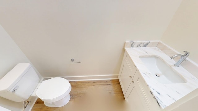 bathroom with baseboards, vanity, and toilet