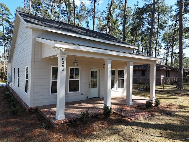 rear view of house with a porch and fence