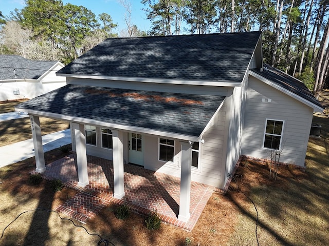 exterior space featuring roof with shingles and a patio