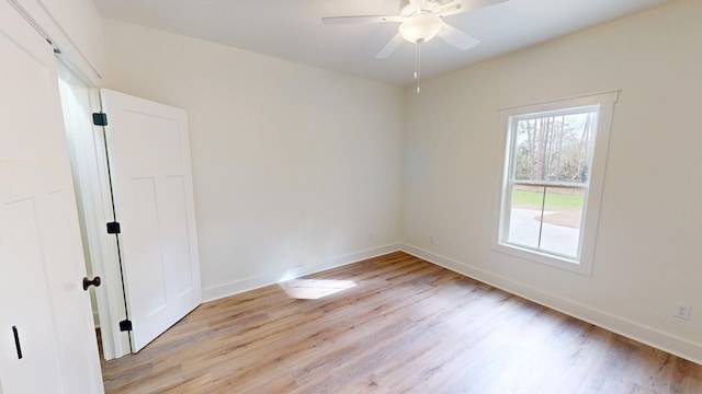 unfurnished room featuring a ceiling fan, light wood-type flooring, and baseboards