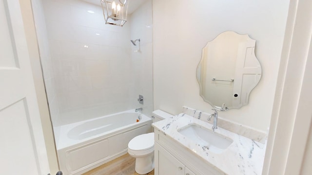 bathroom featuring shower / washtub combination, vanity, toilet, and wood finished floors