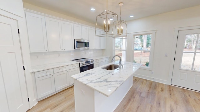 kitchen with stainless steel appliances, white cabinetry, and a sink