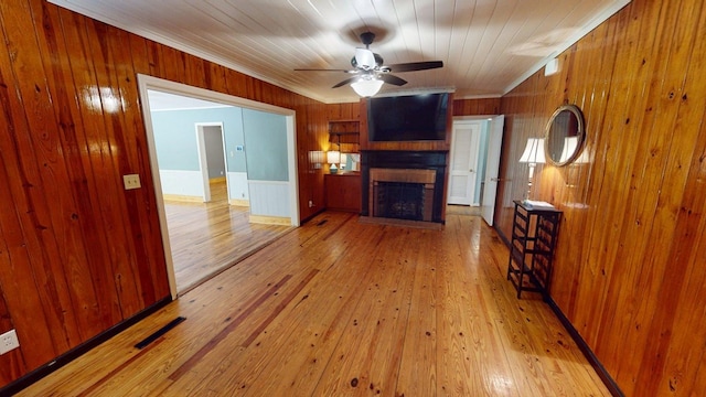 610 Partridge Dr, Thomasville, GA 31792 - unfurnished living room with wooden walls, a fireplace, hardwood / wood-style flooring, ceiling fan, and ornamental molding
