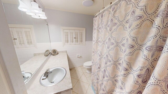 610 Partridge Dr, Thomasville, GA 31792 - bathroom featuring tile walls, tile patterned floors, toilet, vanity, and wainscoting
