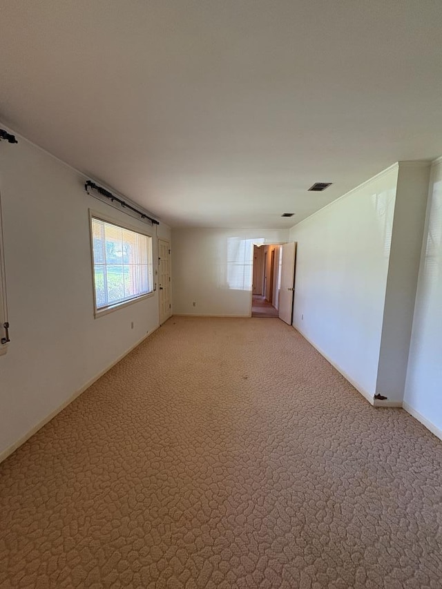 empty room with light carpet, visible vents, and baseboards