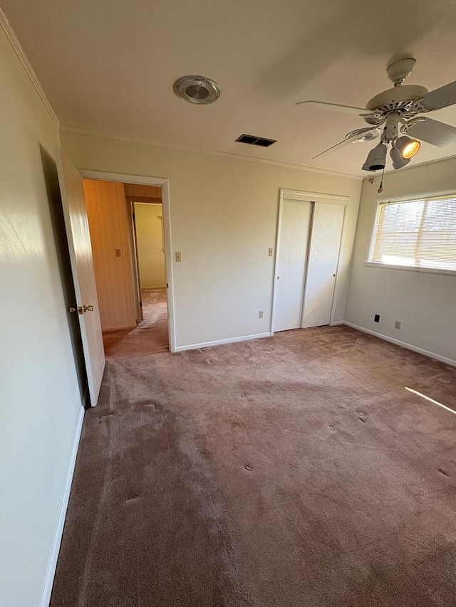 unfurnished bedroom featuring crown molding, baseboards, visible vents, and carpet floors