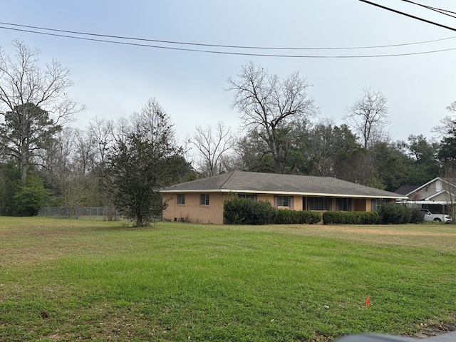 view of front of home featuring fence and a front lawn